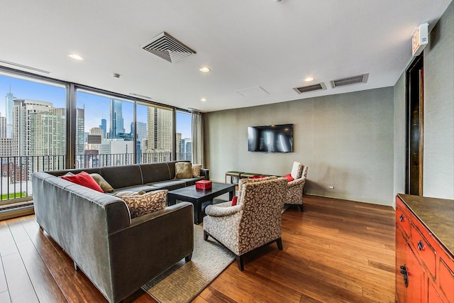living area with wood-type flooring and recessed lighting