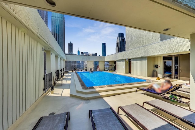 community pool with a view of skyline and a patio