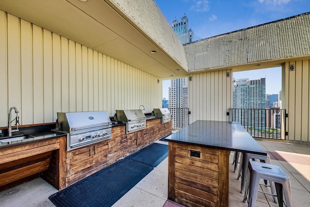 view of patio / terrace with a grill, a sink, exterior kitchen, and a view of city