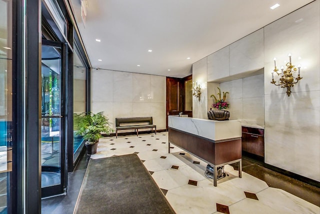 welcome area with tile walls, a chandelier, and recessed lighting