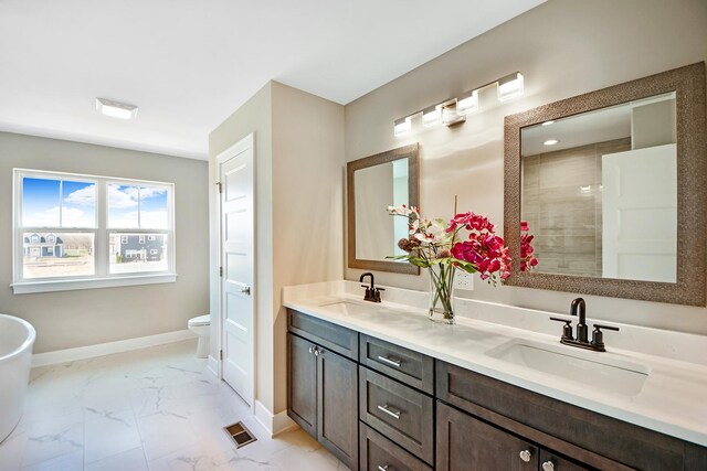 24465 S St Peters Dr, Channahon, IL 60410 - bathroom featuring baseboards, double vanity, marble look tiles, toilet, and a tile shower