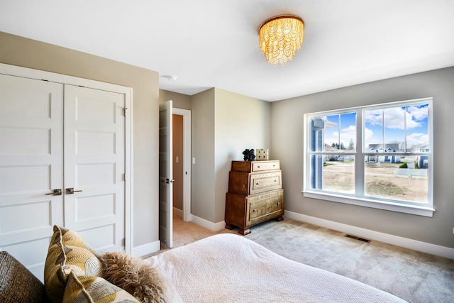 24465 S St Peters Dr, Channahon, IL 60410 - bedroom with light colored carpet, baseboards, a closet, and a chandelier