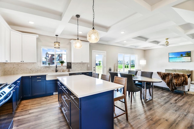 24465 S St Peters Dr, Channahon, IL 60410 - kitchen with a sink, blue cabinetry, coffered ceiling, a breakfast bar, and light wood-style flooring