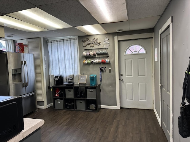 entrance foyer with baseboards, dark wood-style flooring, a drop ceiling, and plenty of natural light