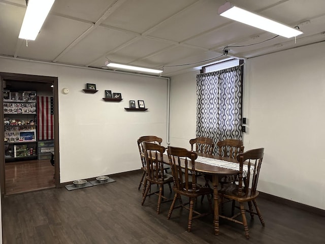 dining space featuring dark wood finished floors and baseboards
