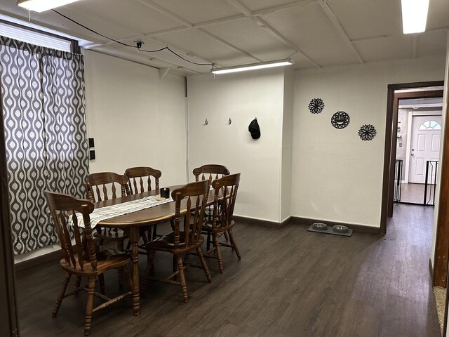 dining space featuring dark wood-type flooring and baseboards