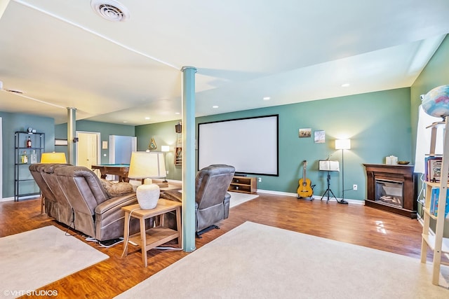7181 Dada Dr, Gurnee, IL 60031 - home theater with wood finished floors, ornate columns, baseboards, a glass covered fireplace, and recessed lighting