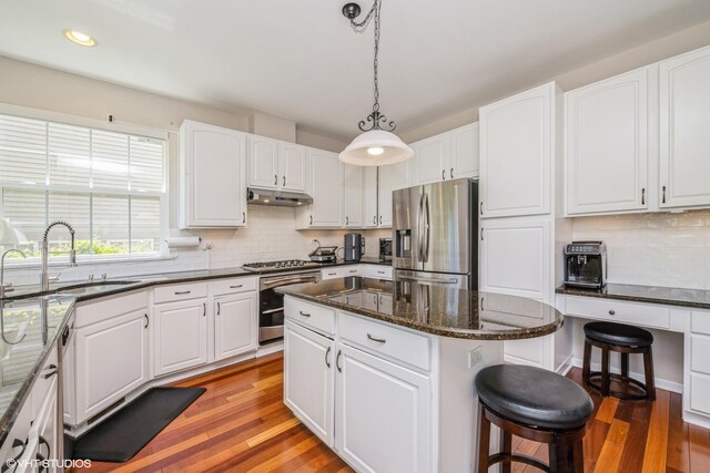 7181 Dada Dr, Gurnee, IL 60031 - kitchen featuring stainless steel fridge, a sink, a kitchen bar, light wood-style flooring, and dark stone countertops
