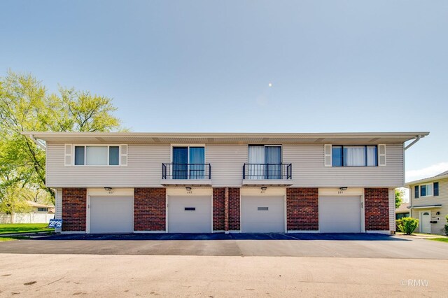 231 Barcliffe Ln Unit 231, Schaumburg, IL 60194 - townhome / multi-family property with brick siding, a balcony, and an attached garage