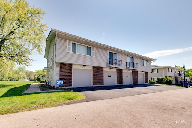 231 Barcliffe Ln Unit 231, Schaumburg, IL 60194 - townhome / multi-family property with brick siding, driveway, a front yard, a garage, and a balcony