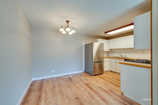 231 Barcliffe Ln Unit 231, Schaumburg, IL 60194 - kitchen featuring freestanding refrigerator, light wood-style flooring, a chandelier, and baseboards