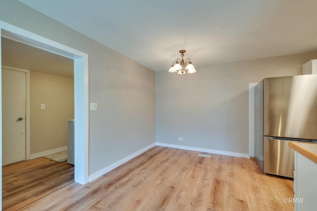 231 Barcliffe Ln Unit 231, Schaumburg, IL 60194 - unfurnished dining area featuring light wood-style flooring, a chandelier, and baseboards
