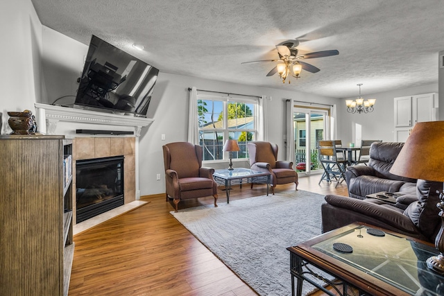 8 Harrison Ct, Bloomington, IL 61704 - living area with a fireplace, ceiling fan, wood finished floors, a chandelier, and a textured ceiling