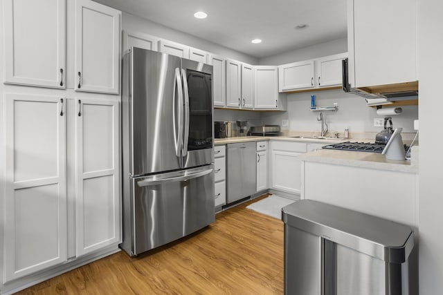 8 Harrison Ct, Bloomington, IL 61704 - kitchen featuring appliances with stainless steel finishes, a sink, light countertops, light wood finished floors, and recessed lighting