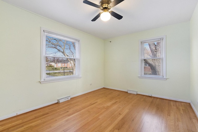 12217 S 68th Ct, Palos Heights, IL 60463 - spare room featuring plenty of natural light, baseboards, light wood-style floors, and a ceiling fan