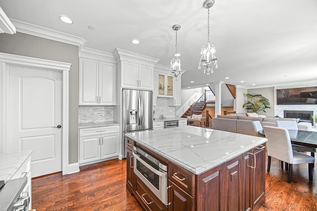 kitchen with stainless steel appliances, crown molding, white cabinetry, a chandelier, and tasteful backsplash