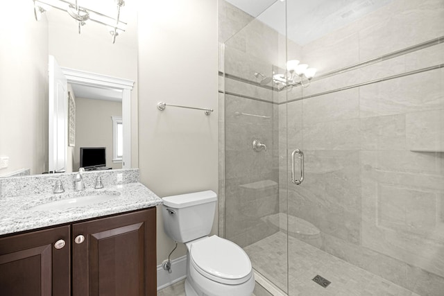 full bath with a chandelier, a stall shower, toilet, and vanity