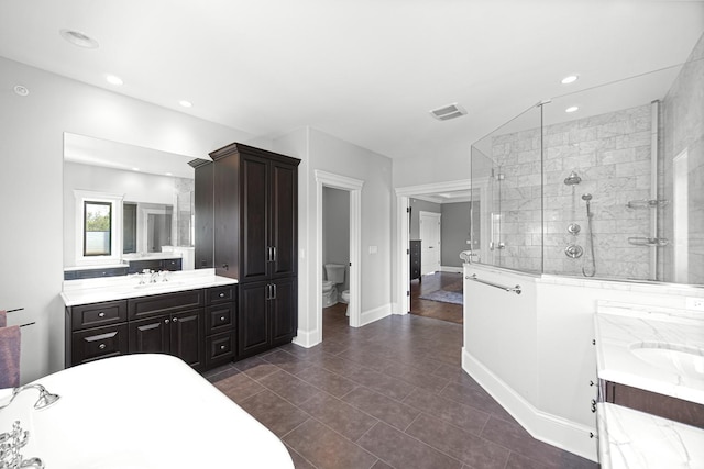 bathroom with a stall shower, vanity, toilet, recessed lighting, and baseboards