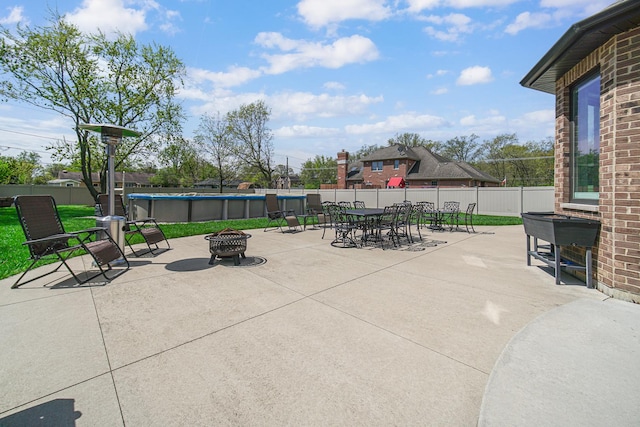 view of patio featuring a fire pit, fence, and outdoor dining space
