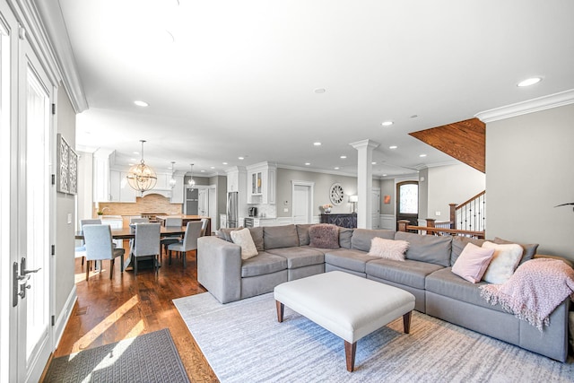 living room featuring ornate columns, recessed lighting, crown molding, dark wood-style flooring, and stairs