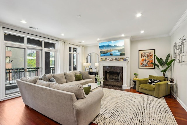 living room featuring crown molding, dark wood-style floors, a premium fireplace, recessed lighting, and baseboards