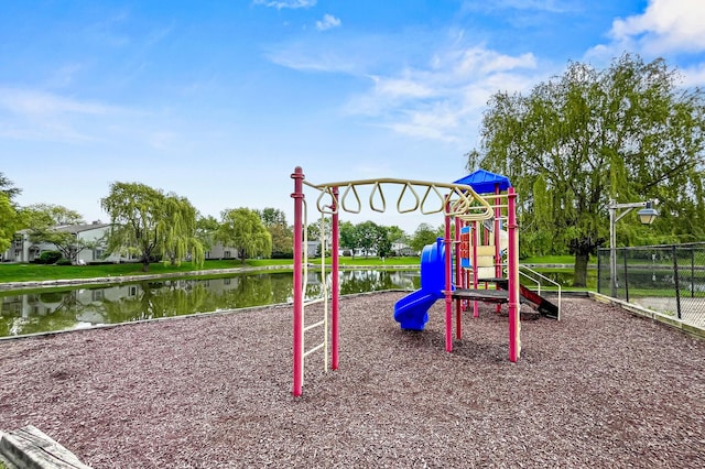 communal playground featuring fence and a water view