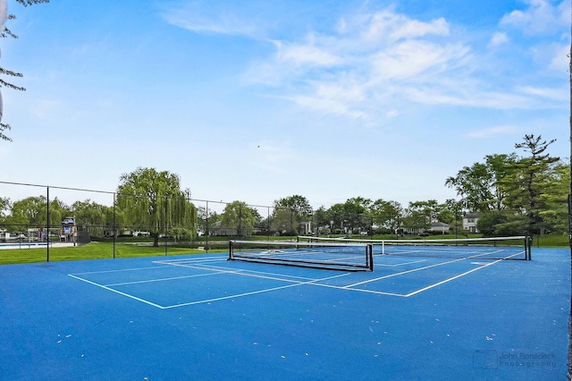 view of tennis court with fence and community basketball court
