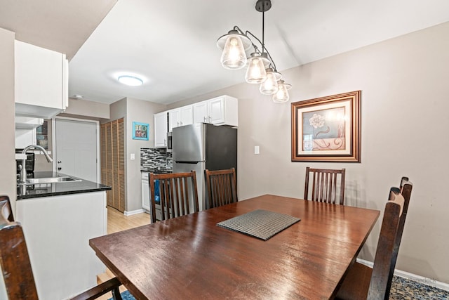 dining area featuring light wood-style floors and baseboards
