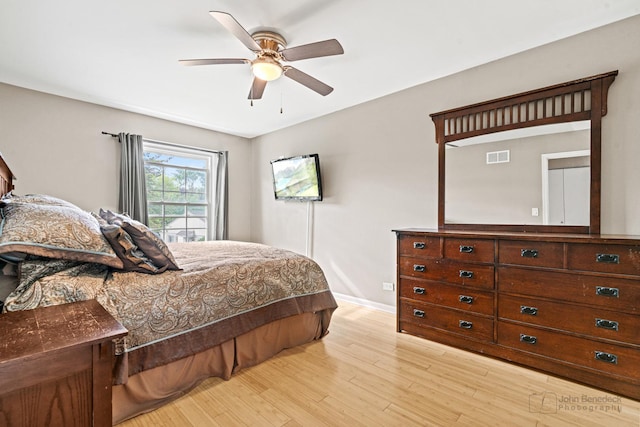 bedroom with light wood finished floors, baseboards, and a ceiling fan