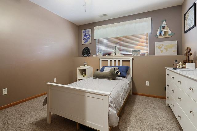 bedroom featuring light carpet and baseboards