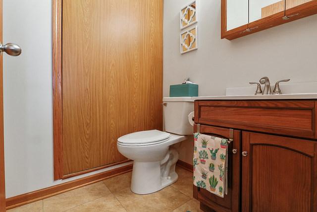 bathroom featuring toilet, tile patterned flooring, vanity, and baseboards