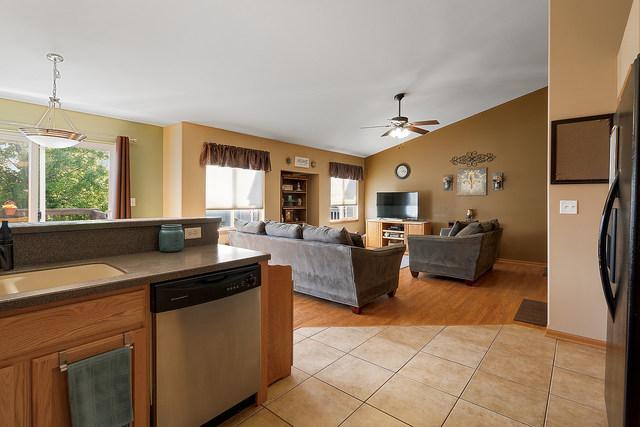 kitchen featuring dishwasher, freestanding refrigerator, a ceiling fan, light tile patterned floors, and a sink