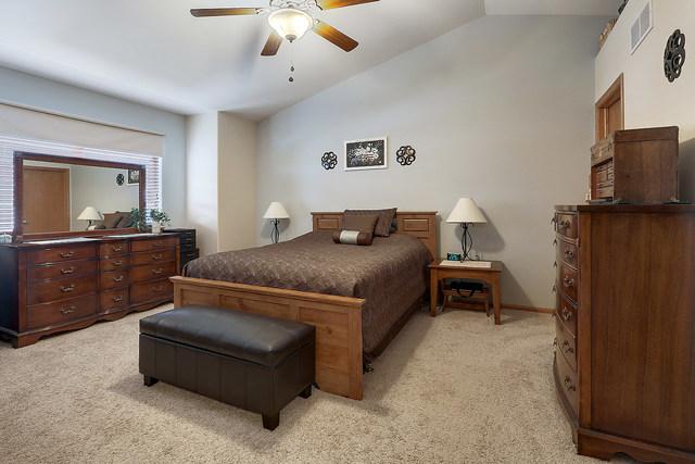 bedroom with lofted ceiling, light carpet, and ceiling fan