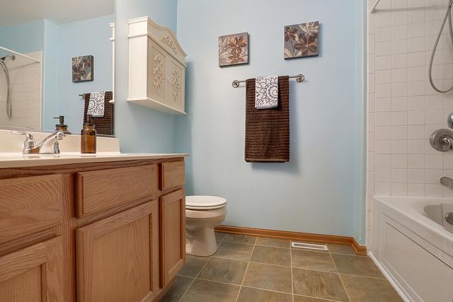 bathroom with shower / tub combination, toilet, vanity, and baseboards