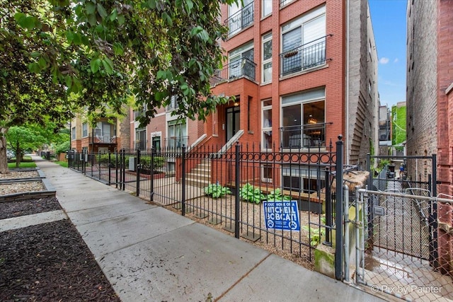 2447 W Walton St Unit 1, Chicago, IL 60622 - view of front of home with a fenced front yard, brick siding, and a gate