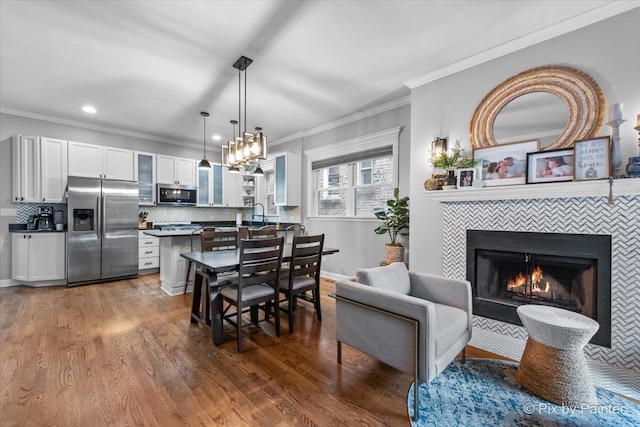 2447 W Walton St Unit 1, Chicago, IL 60622 - dining area with ornamental molding, dark wood-style floors, recessed lighting, a tiled fireplace, and baseboards