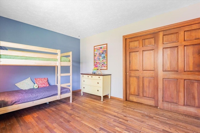 2201 Hedgewood Dr, Bloomington, IL 61704 - bedroom featuring wood finished floors, a textured ceiling, and baseboards