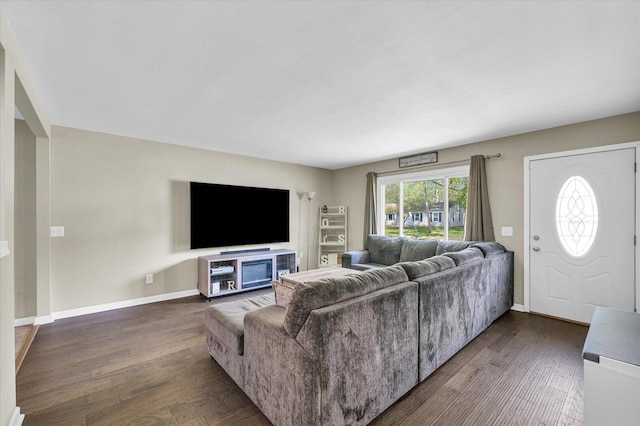 living room featuring dark wood-type flooring and baseboards