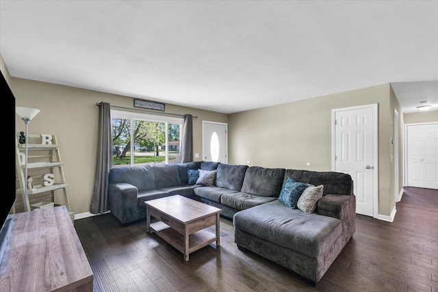 living area featuring dark wood-style flooring and baseboards