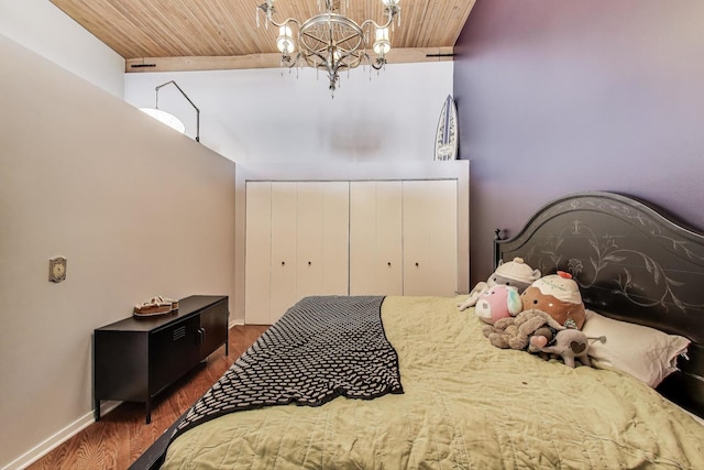 bedroom featuring a chandelier, wood ceiling, wood finished floors, baseboards, and a high ceiling