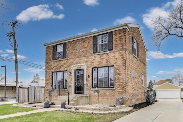 view of front of house featuring brick siding, an outbuilding, a detached garage, and fence