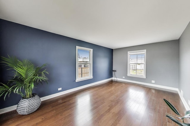unfurnished room featuring baseboards and wood finished floors