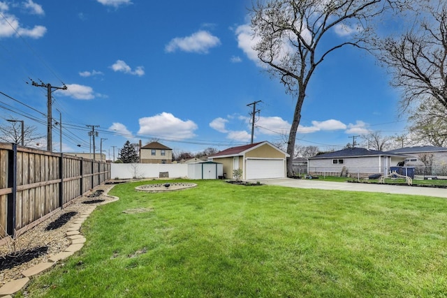 view of yard featuring an outbuilding, a storage shed, a garage, and concrete driveway