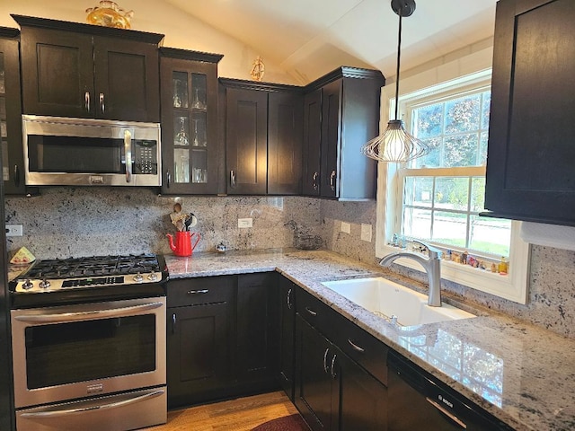 213 W Park Ave, Wheaton, IL 60189 - kitchen featuring appliances with stainless steel finishes, a sink, vaulted ceiling, decorative backsplash, and glass insert cabinets