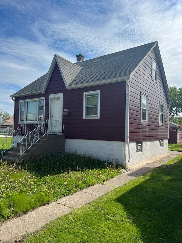 14027 S Mackinaw Ave, Burnham, IL 60633 - view of front of home featuring roof with shingles, a chimney, and a front yard