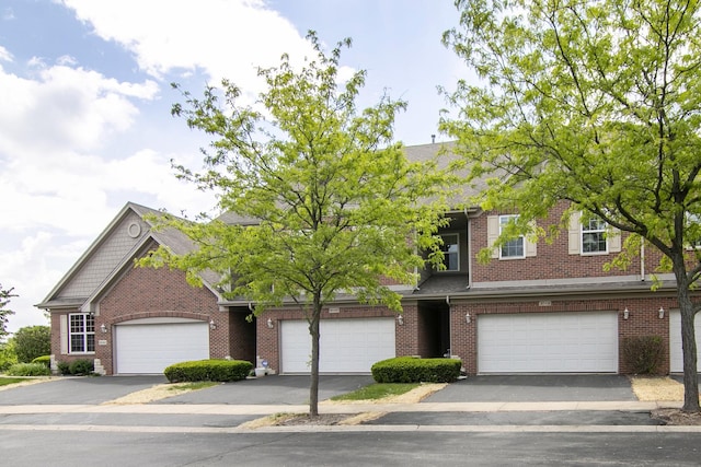 view of front of house with brick siding, driveway, and a garage