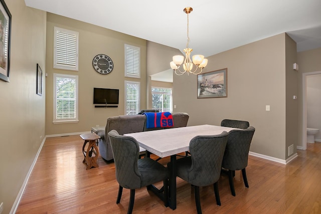 dining area featuring baseboards, a chandelier, and light wood-type flooring