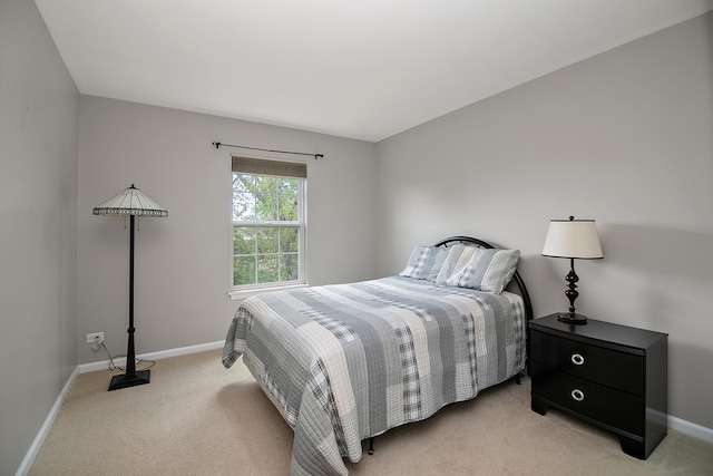 bedroom featuring light carpet and baseboards