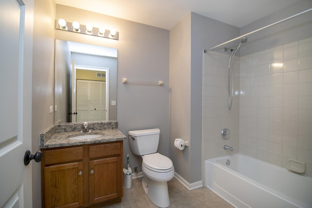 bathroom featuring tile patterned floors, toilet, vanity, washtub / shower combination, and baseboards