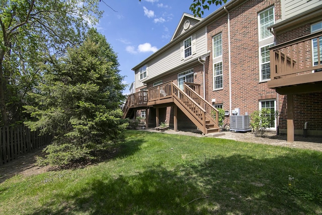 back of house featuring central AC, stairs, brick siding, and a wooden deck